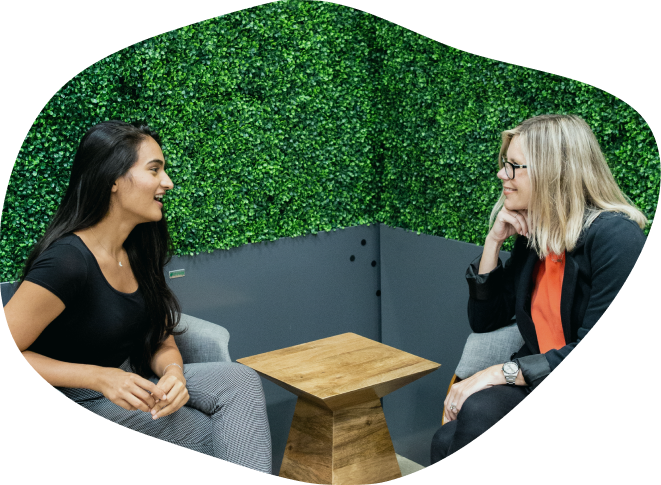 Two women talking in a lush office space